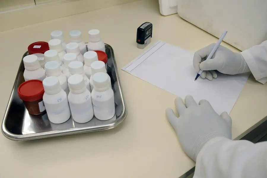 Operatore con guanti registra i campioni disposti su un vassoio sterile