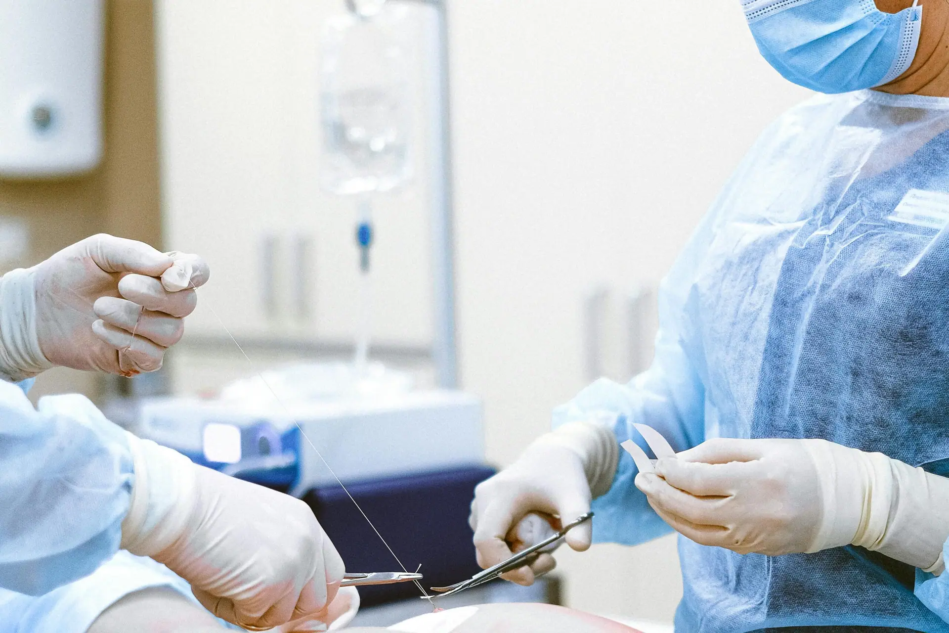 Personale sanitario in sala operatoria passa uno strumento chirurgico sterile