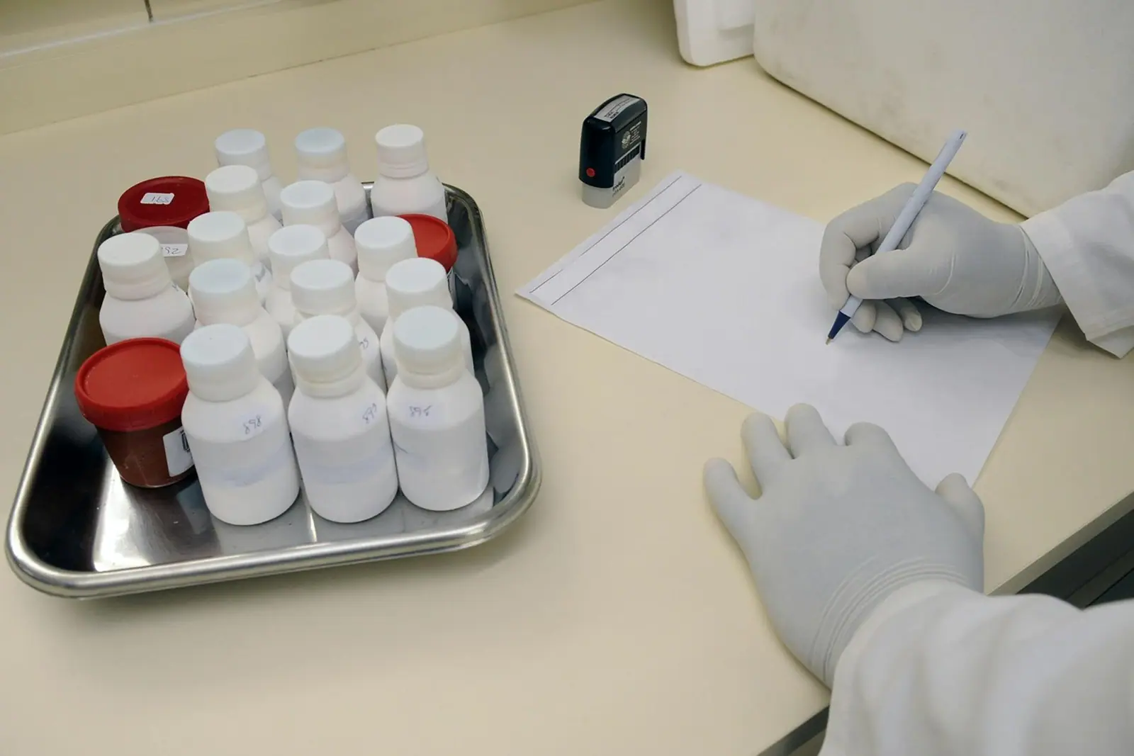 Operatore di laboratorio prepara campioni farmaceutici su vassoio sterile